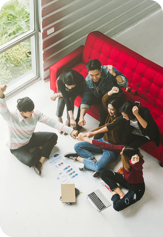 Person writing notes at a desk with laptop and documents