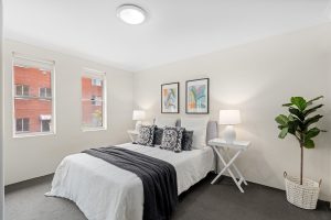 Staged bedroom with double bed, bedside tables, and soft neutral finishes