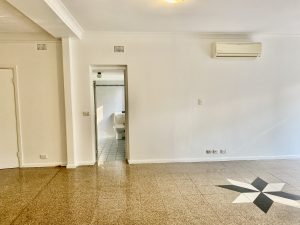 Living room wall with split-system air conditioning and terrazzo flooring at 35 Churchill Crescent, Concord NSW 2137