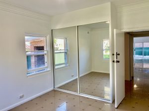 Bedroom with mirrored built-in wardrobe and window at 35 Churchill Crescent, Concord NSW