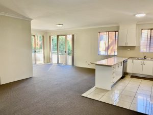 Open-plan living and dining area with adjoining kitchen and sliding doors to balcony at 7/39–43 Station Street, Mortdale NSW 2223