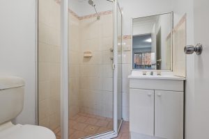 Bathroom with shower enclosure, vanity, and tiled flooring at 13/14–16 Cairns Street, Riverwood NSW 2210
