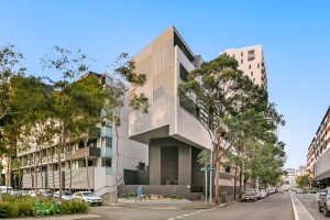 Street-corner apartment building with contemporary façade, layered balconies, and surrounding trees at 5/1 Defries Avenue, Zetland NSW 2017
