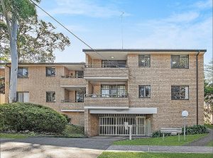 Exterior view of a beige brick apartment building with balconies and secure entry at 6/4 Alma Street, Hurstville NSW