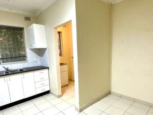 Compact kitchen and adjoining laundry area at 5/147 The Boulevarde, Punchbowl NSW 2196