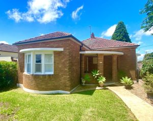 Front exterior of brick house at 98 Penshurst Street Penshurst NSW with curved bay window, tiled roof, and covered entry porch