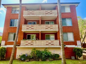 Exterior of a red brick apartment building with balconies at 9/48 Station Street, Mortdale NSW 2223