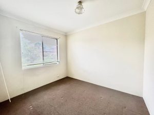 Empty bedroom with carpeted floor, single window with blinds, and neutral walls at 4/81–83 Dora Street, Hurstville NSW 2220