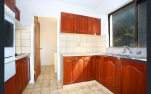 Kitchen with timber cabinetry, tiled flooring, stainless steel sink, and window at 4/81–83 Dora Street, Hurstville NSW 2220