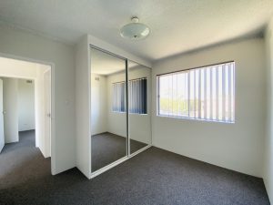Bedroom with mirrored built-in wardrobe and window at 4/25 Romilly Street, Riverwood NSW 2210