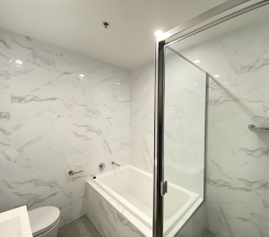 Modern bathroom with bathtub and frameless glass shower screen at 11/2a Selmon St, Sans Souci NSW 2219