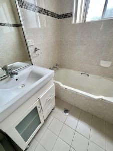 Bathroom with bathtub, vanity and tiled walls at 3/52 Woids Ave, Hurstville NSW 2220