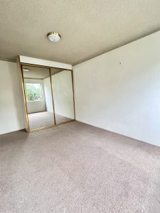 Bedroom with mirrored built-in wardrobe and carpeted flooring at 3/52 Woids Ave, Hurstville NSW 2220