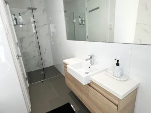 Modern bathroom with walk-in shower and timber vanity at 31A Lawrence St Peakhurst NSW 2210