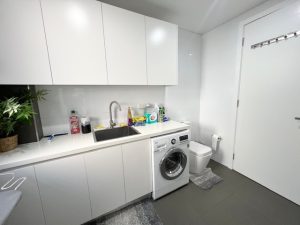 Modern laundry with integrated cabinetry, sink and washing machine at 31A Lawrence Street, Peakhurst