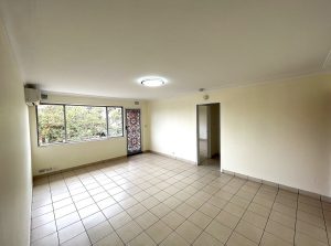 Spacious tiled living room with large window and neutral walls at 4/48 Fairmount St, Lakemba NSW 2195
