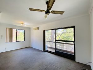 Living room with ceiling fan, carpeted flooring, and sliding glass doors opening to a balcony at 5/35-39 Martin Place Mortdale NSW 2223